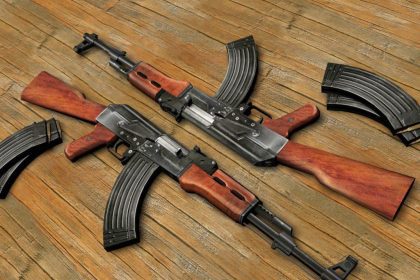 Two AK-47 assault rifles lying on textured surface, contrasting the compact submachine guns featured in the article about SMG evolution in military and special ops use.