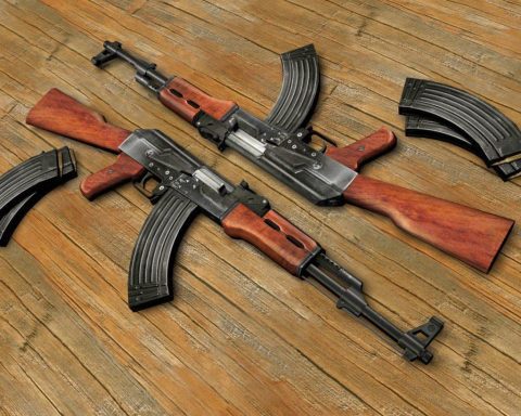 Two AK-47 assault rifles lying on textured surface, contrasting the compact submachine guns featured in the article about SMG evolution in military and special ops use.