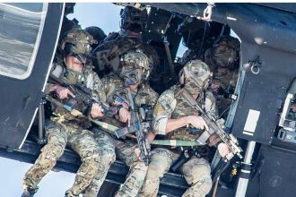 A group of Delta Force operators armed with HK416 assault rifles hanging out from the Blackhawk