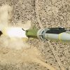 GLSDB cruise missile in mid-flight with its ground-based artillery launch system visible in the background, demonstrating modern precision strike technology that minimizes collateral damage