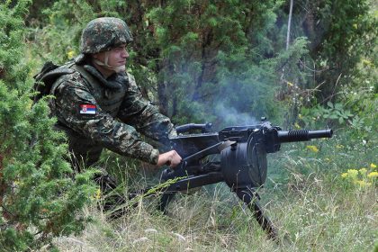 Serbian soldier firing Zastava M93 BGA automatic grenade launcher in a field setting