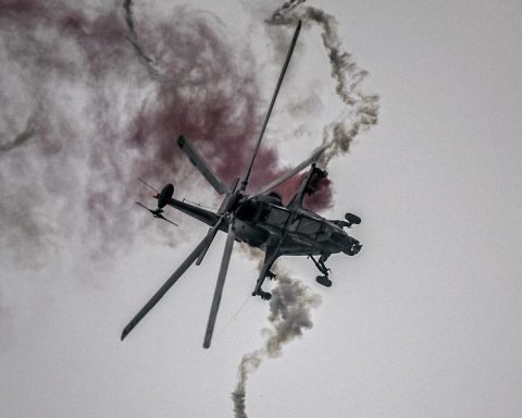 CAIC Z-10 attack helicopter in flight deploying defensive flares during evasive maneuvers.
