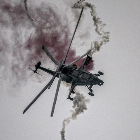 CAIC Z-10 attack helicopter in flight deploying defensive flares during evasive maneuvers.