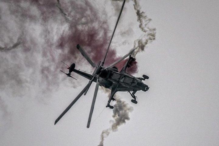 CAIC Z-10 attack helicopter in flight deploying defensive flares during evasive maneuvers.